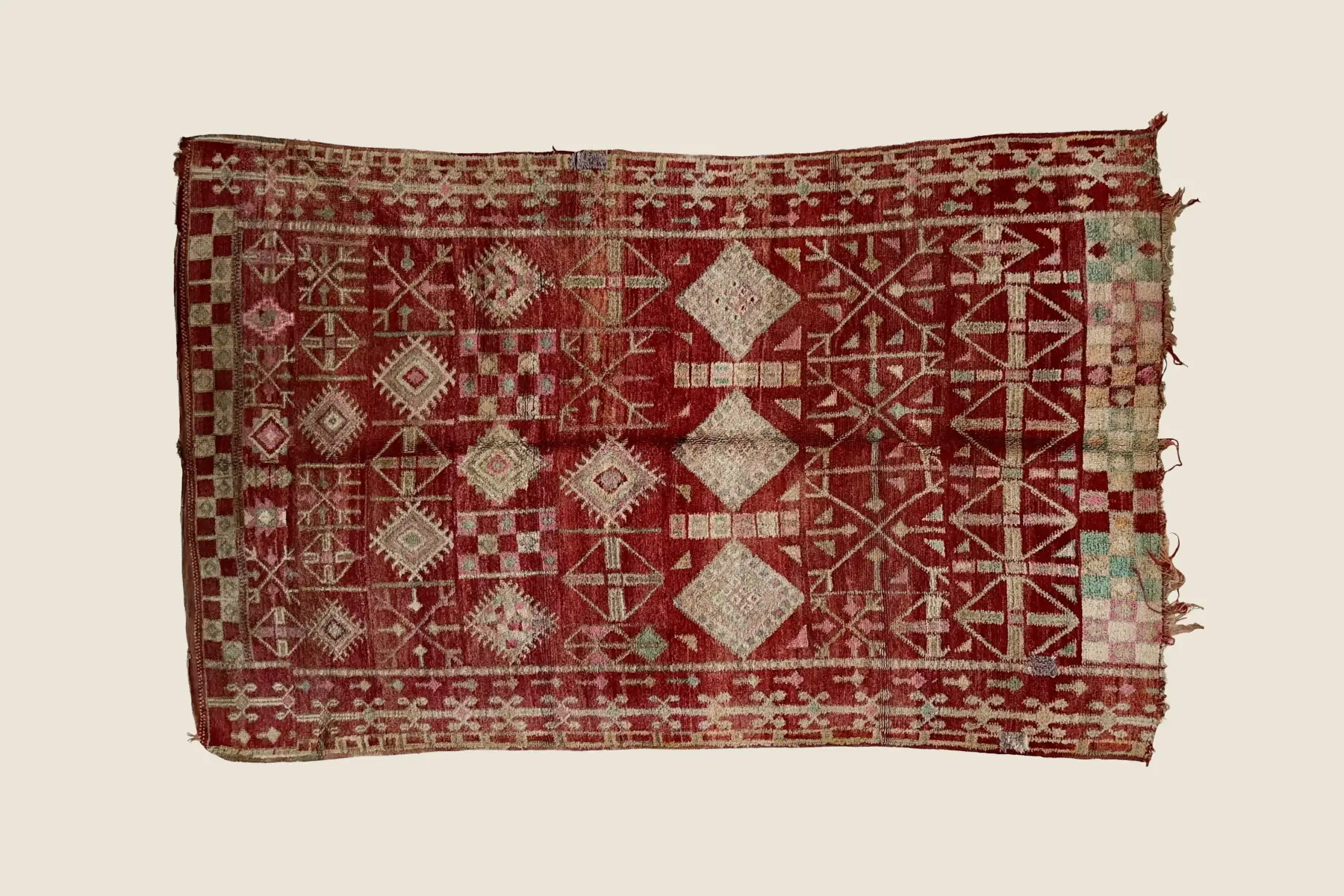 Beni M'Guild wool texture detail showing hand-knotted geometric motifs in dark red and warm beige