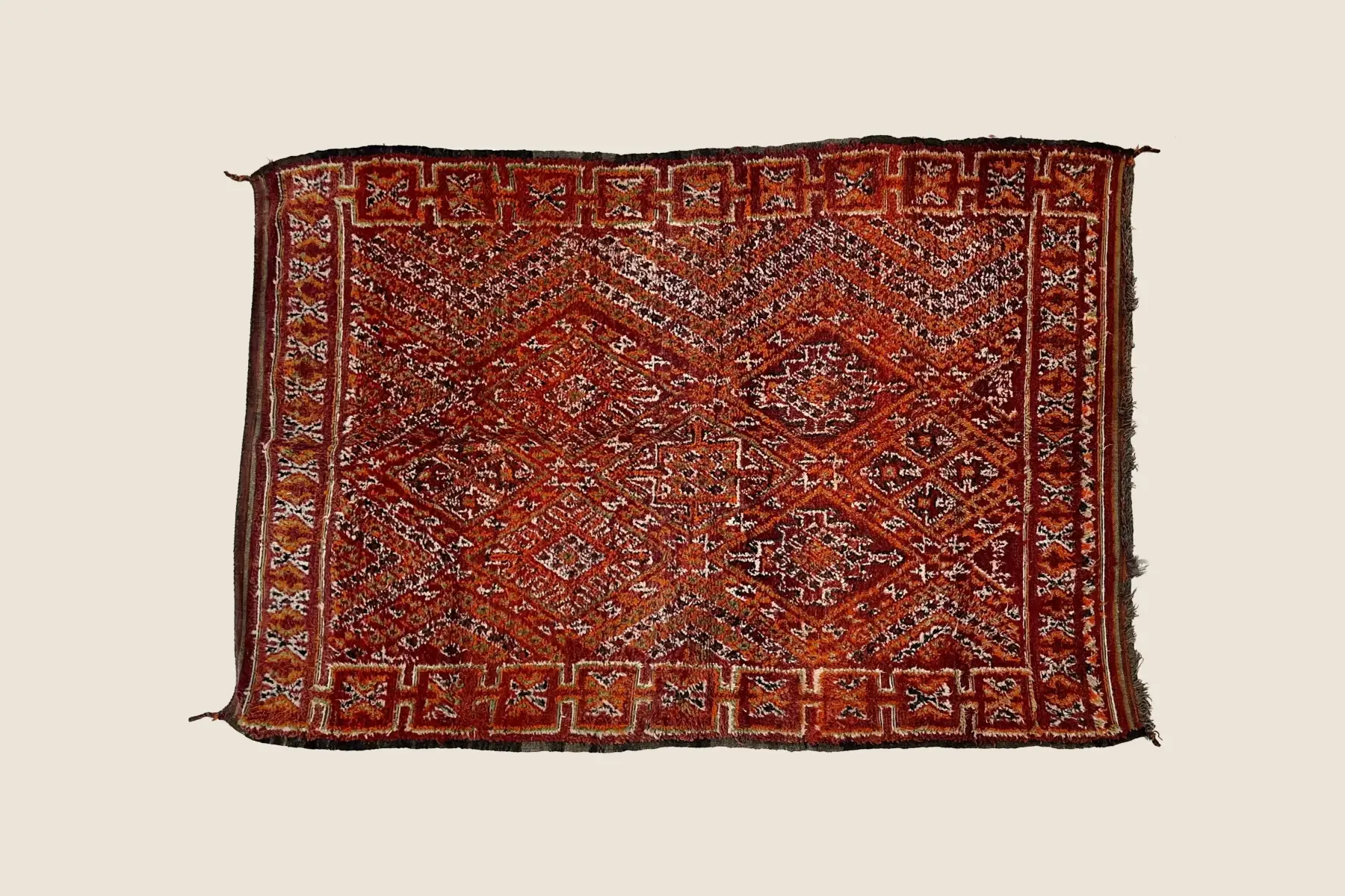 Beni M'Guild rug detail showing hand-knotted wool texture with deep burgundy, rust, and olive geometric motifs