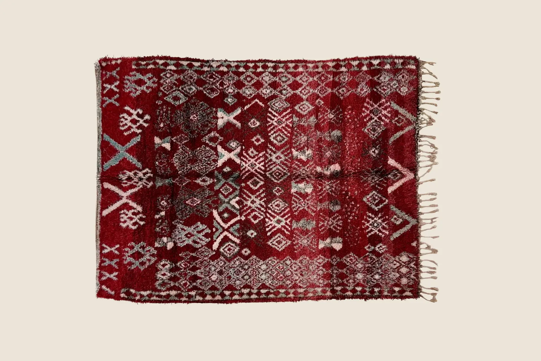 Beni M'Guild wool texture showing hand-knotted teal, red, and beige geometric motif detail