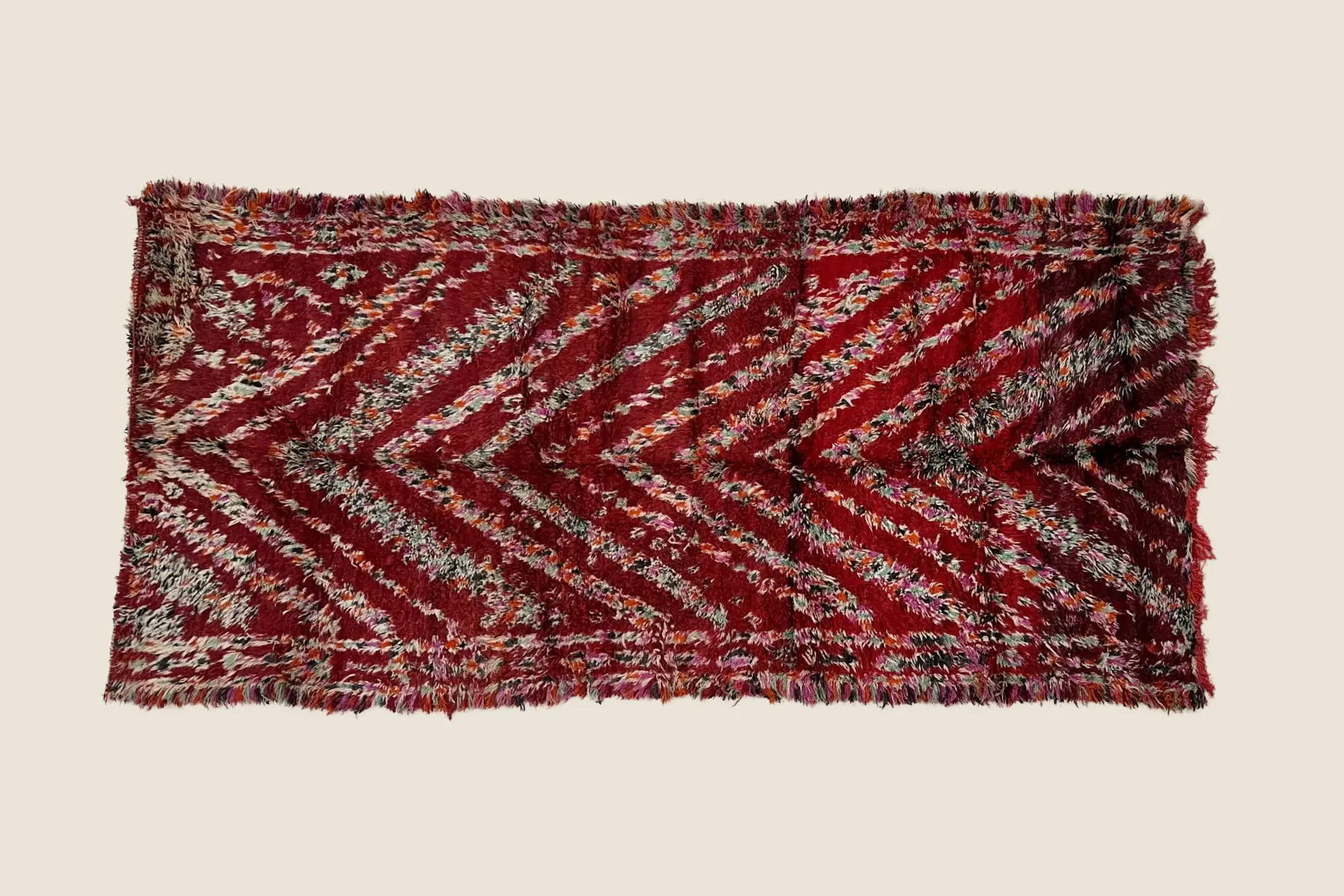 Marmoucha rug detail showing crimson red and rose pink wool weave texture with artisan hand-knotting craftsmanship