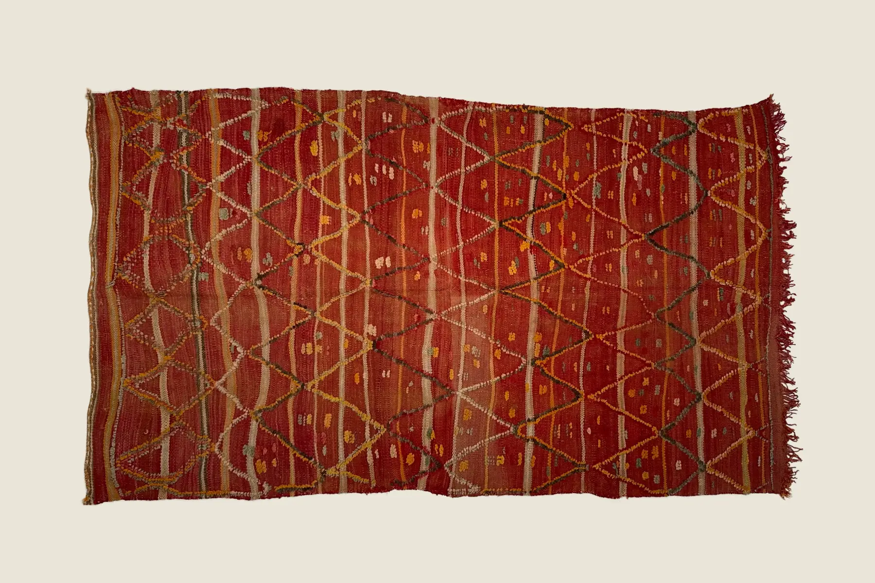 Talsint rug detail showing hand-knotted brick red and orange wool texture - artisanal craftsmanship