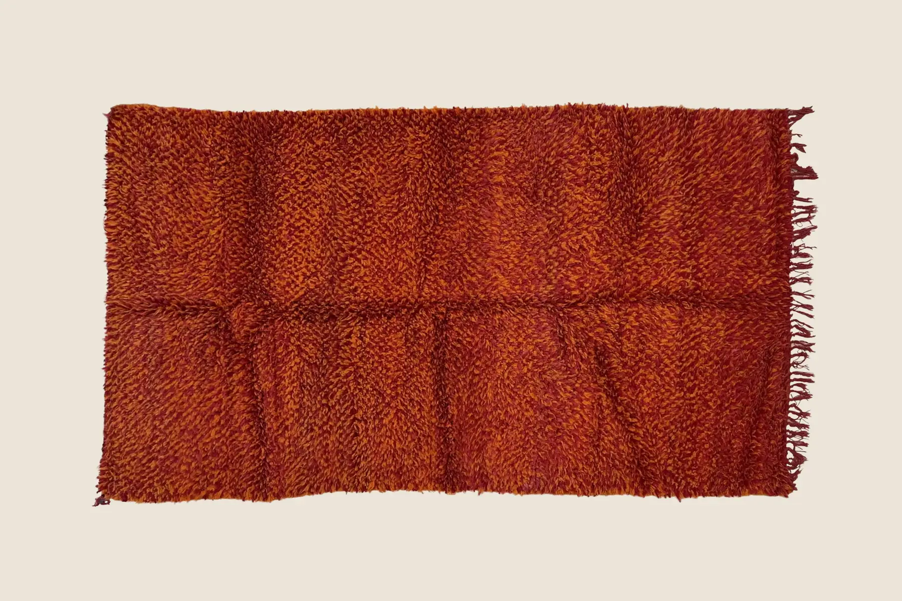 Beni M'Guild wool texture showing hand-knotted crimson accents and warm orange weave detail