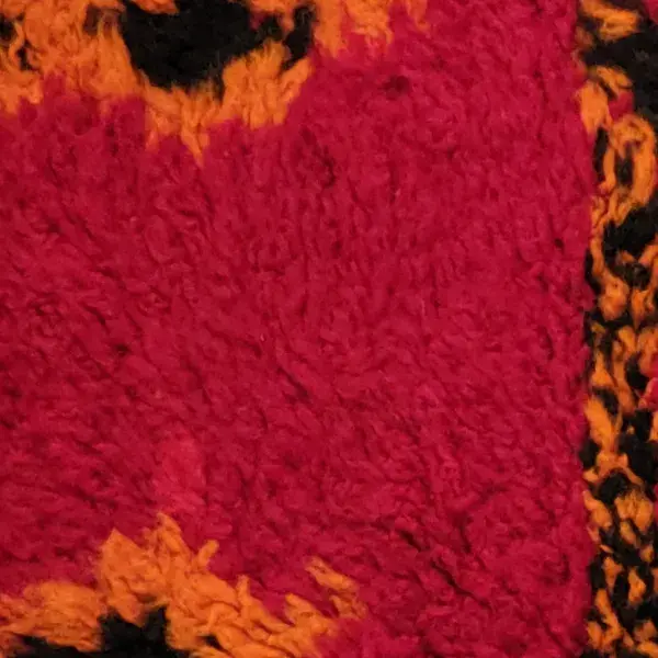 Deep rose red diamond pattern on a black rug.