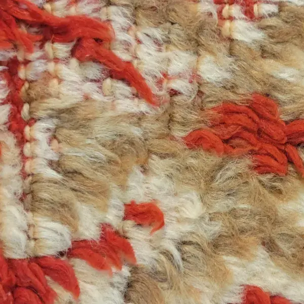 Textured rug swatch in a warm gray-beige with orange undertones.