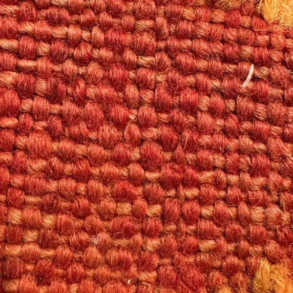 A zigzag symbol in a brick red color.